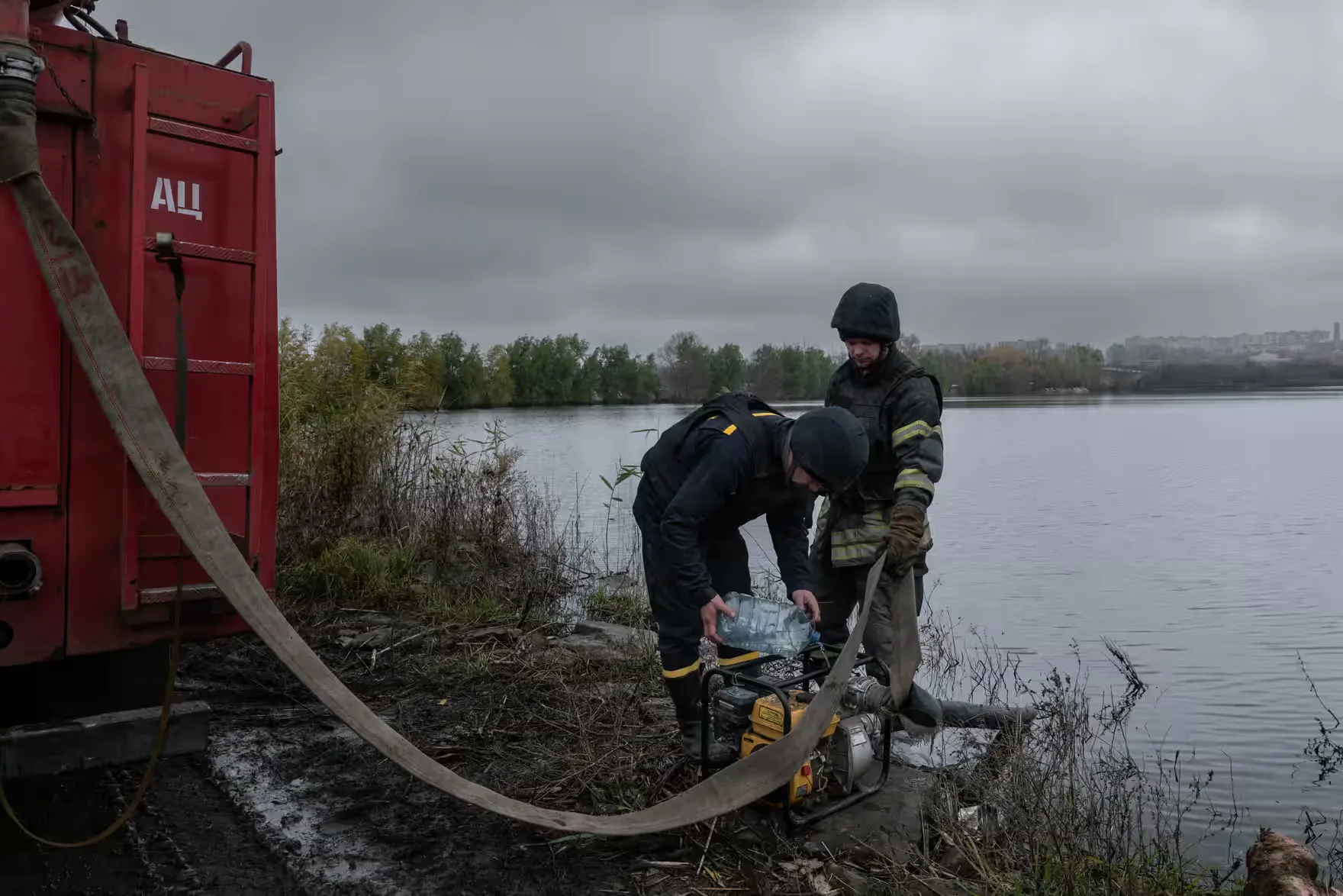 Пожежники з прифронтового міста Бахмут заповнюють свою пожежну машину водою з сусіднього озера. В обложеному східному місті немає проточної води (листопад 2022 року).